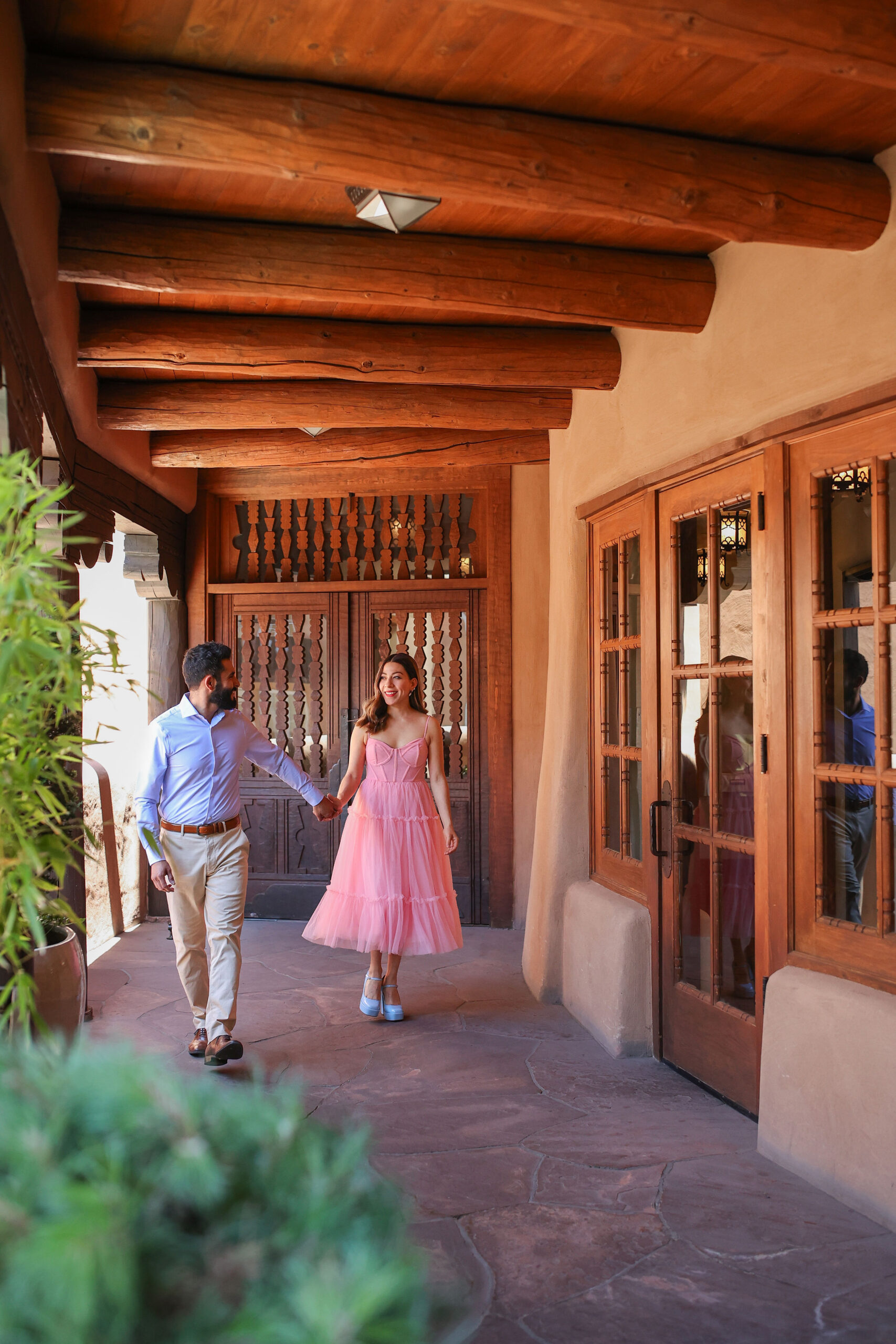 Armando and Marisol holding hands and walking through La Fonda