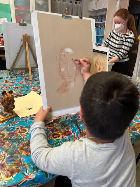 boy artist drawing picture of face