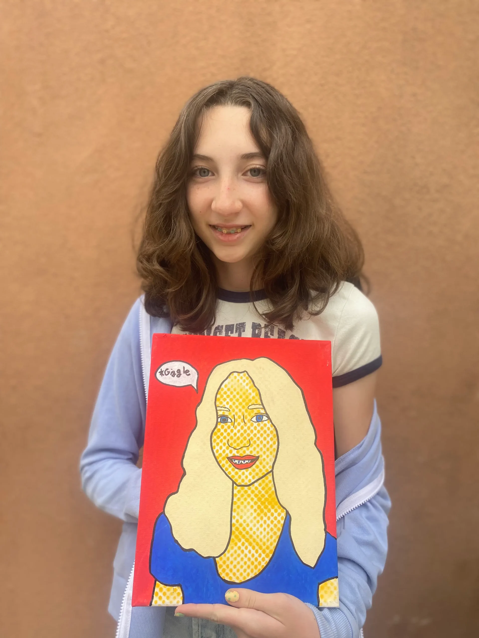 young girl artists holding self-portrait artwork in cool style