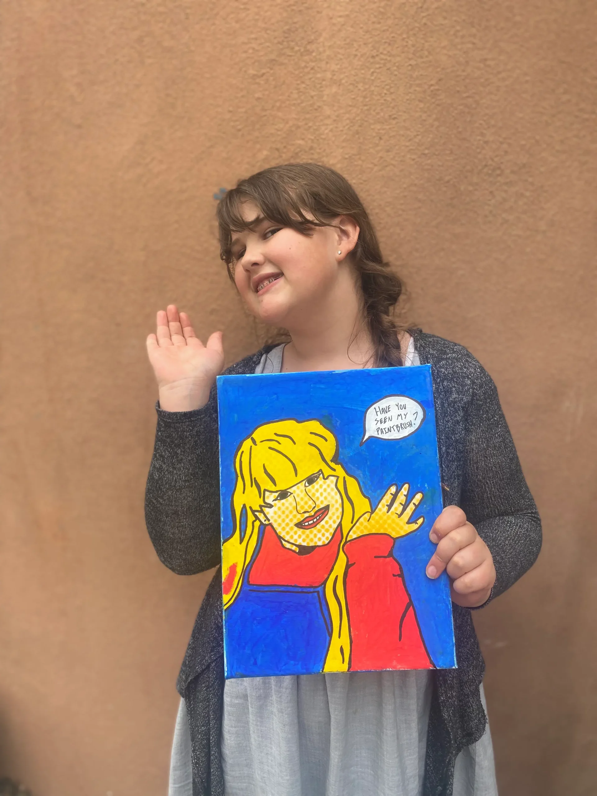 girl art student holding artwork of herself doing a pose