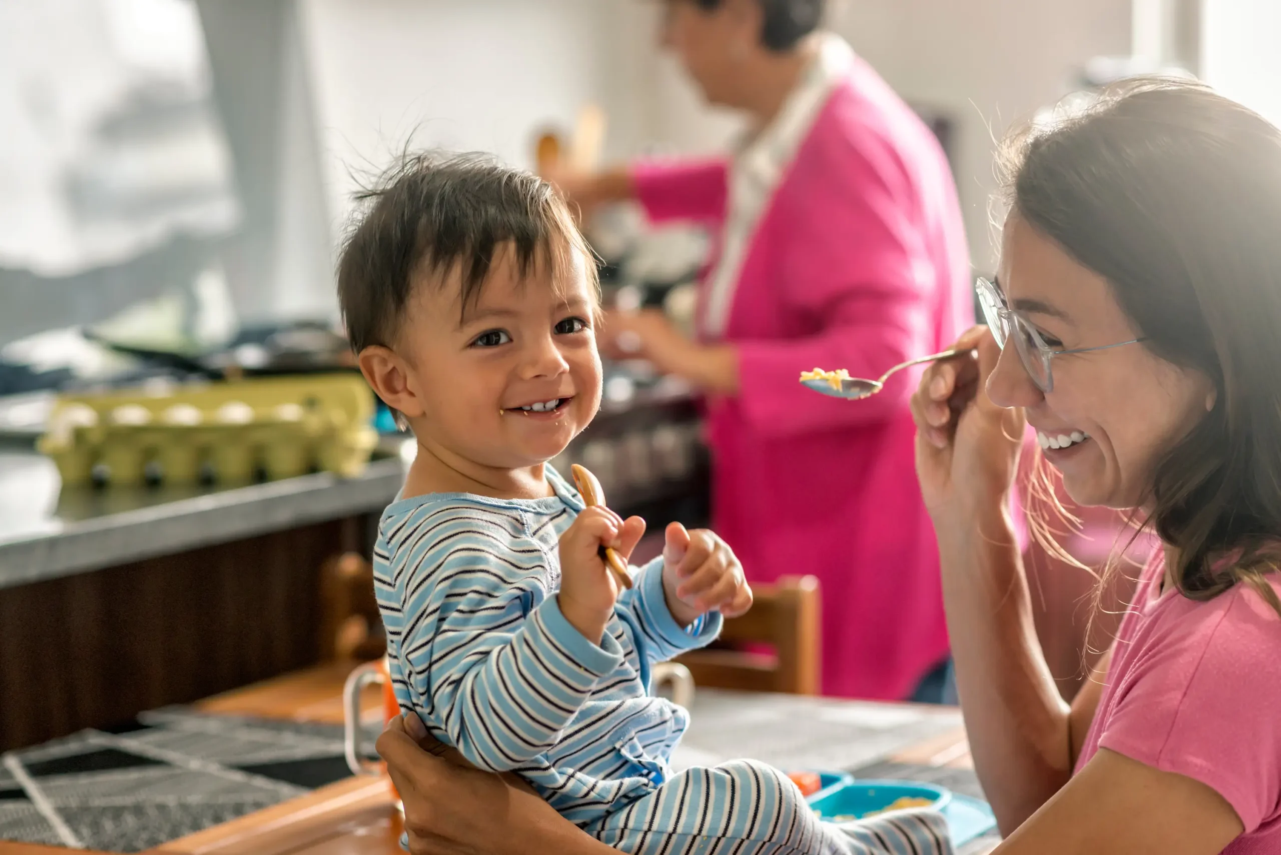 woman feeding happy baby