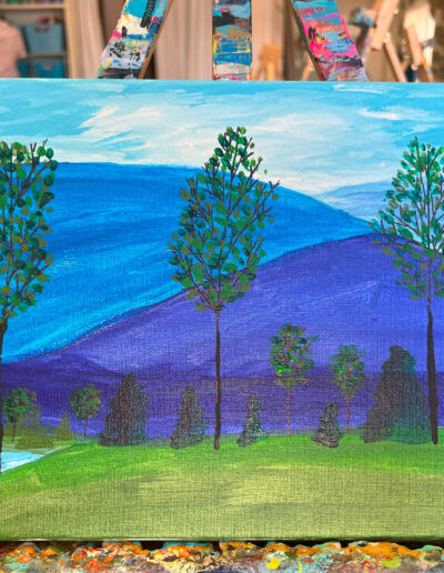 Painting of three trees in front of blue mountains