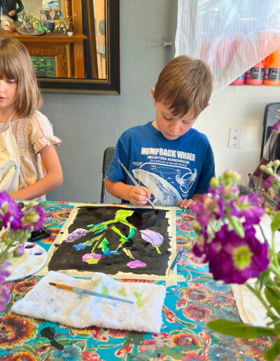 Young boy painting flowers