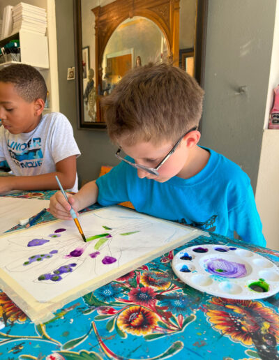 Boy with glasses painting flowers