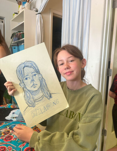 Young girl displaying her self-portrait drawing