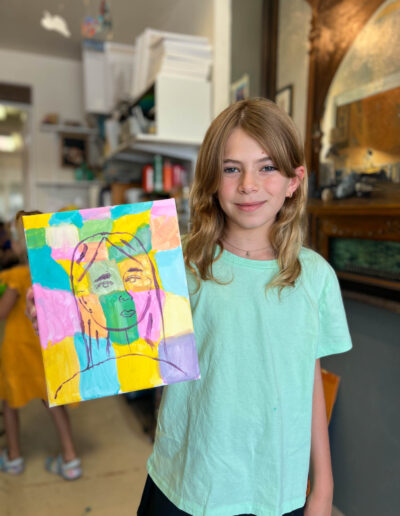 a young student shows her colorful artwork