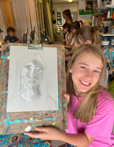 student displays her self portrait