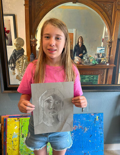 young girl shows her self-portrait