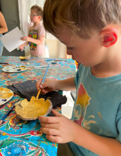 young boy paints pottery