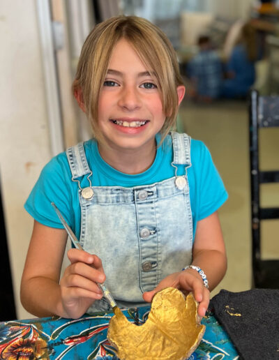 young girl paints pottery