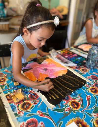 young girl paints in studio