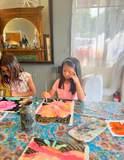 two young girls painting pictures