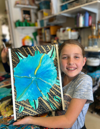 young girl displays her artwork