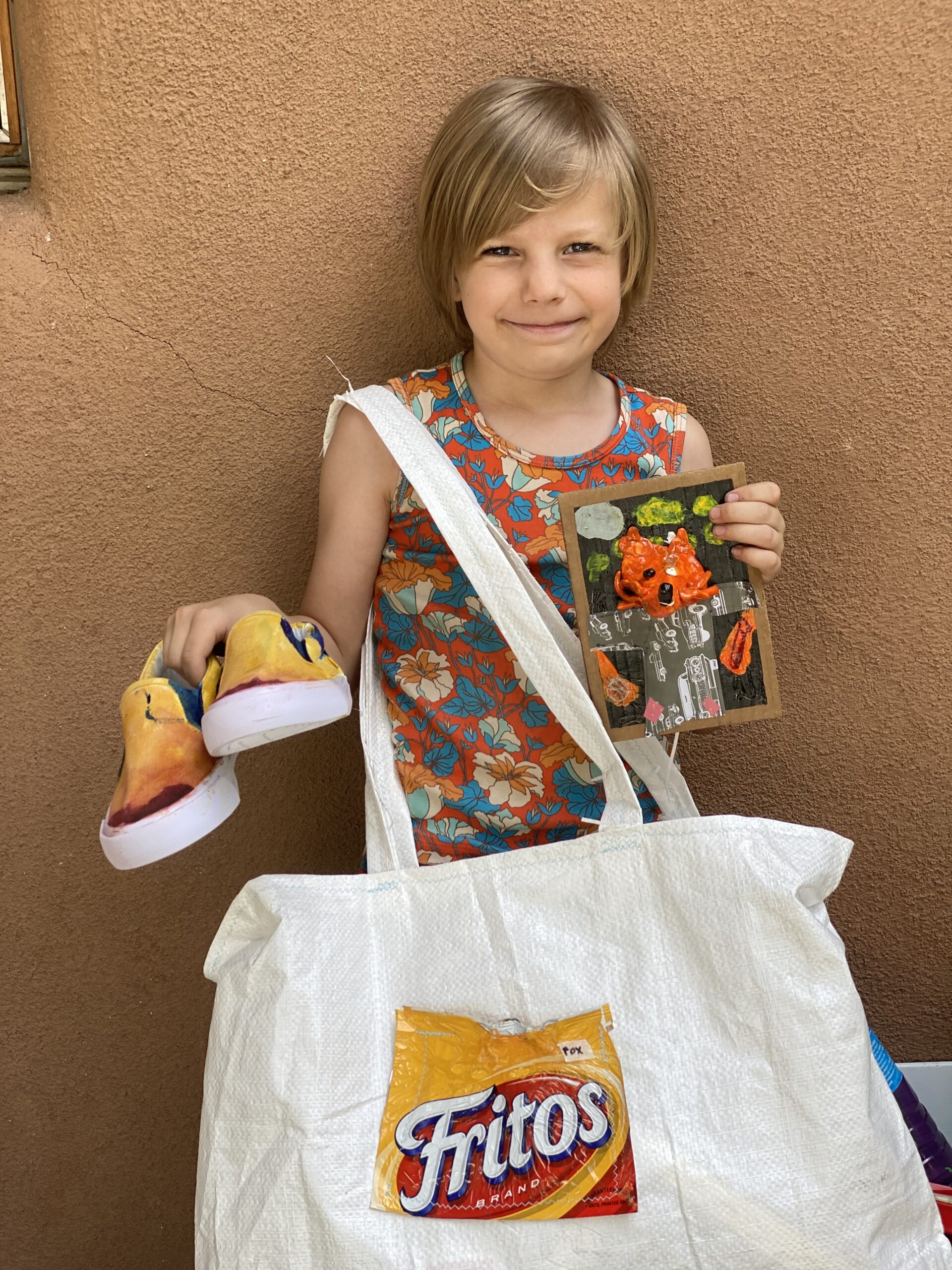 Young girl proudly displaying her painting and painted shoes