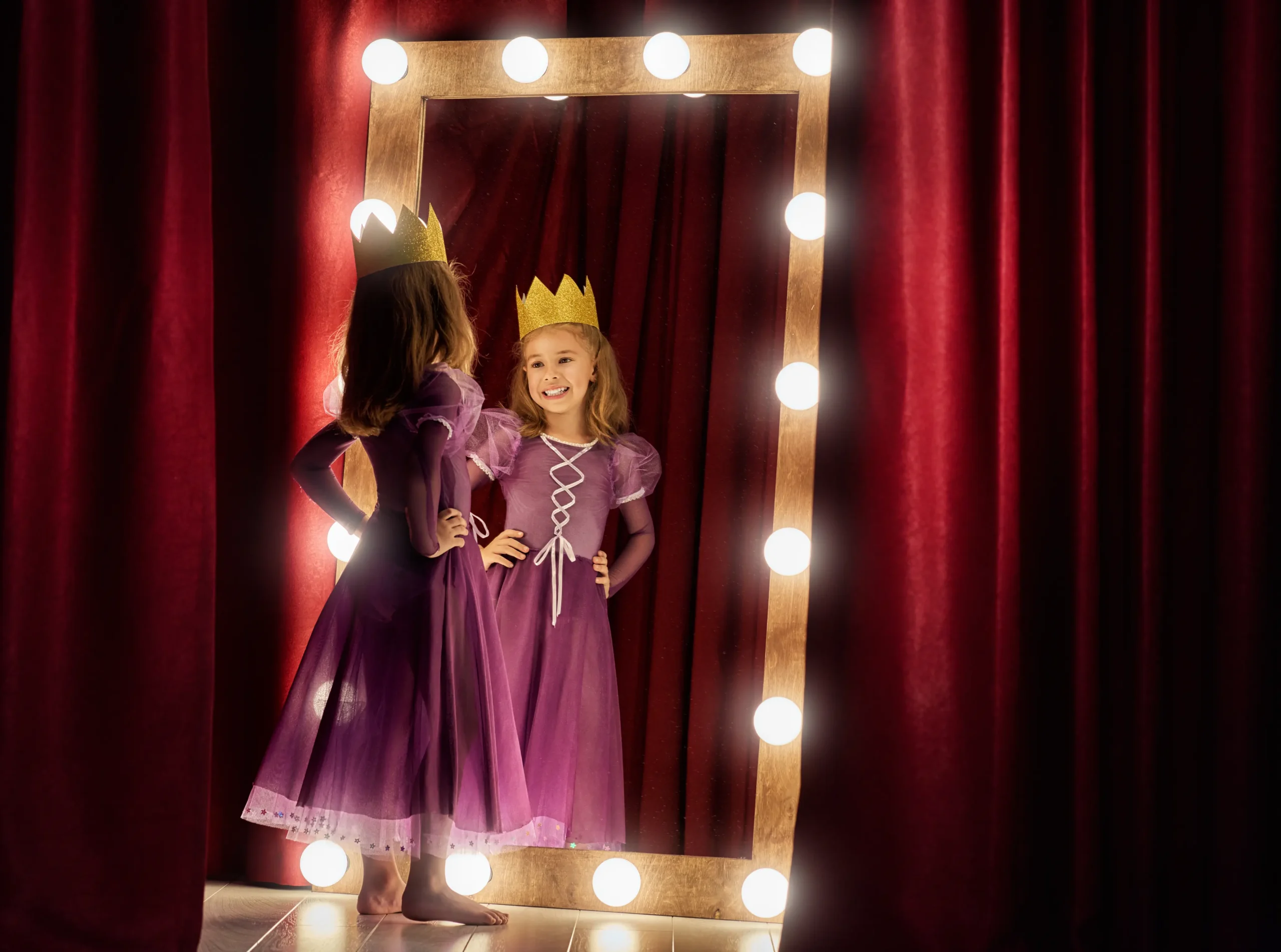 Girl playing as princess in front of mirror