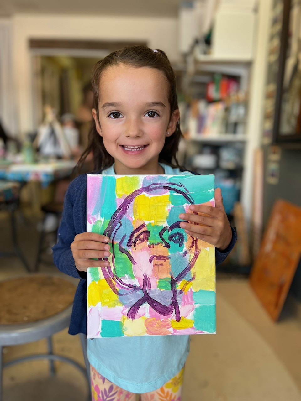 young girl showing off her painting