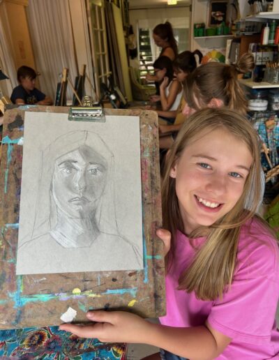 Girl student showing off artwork portrait