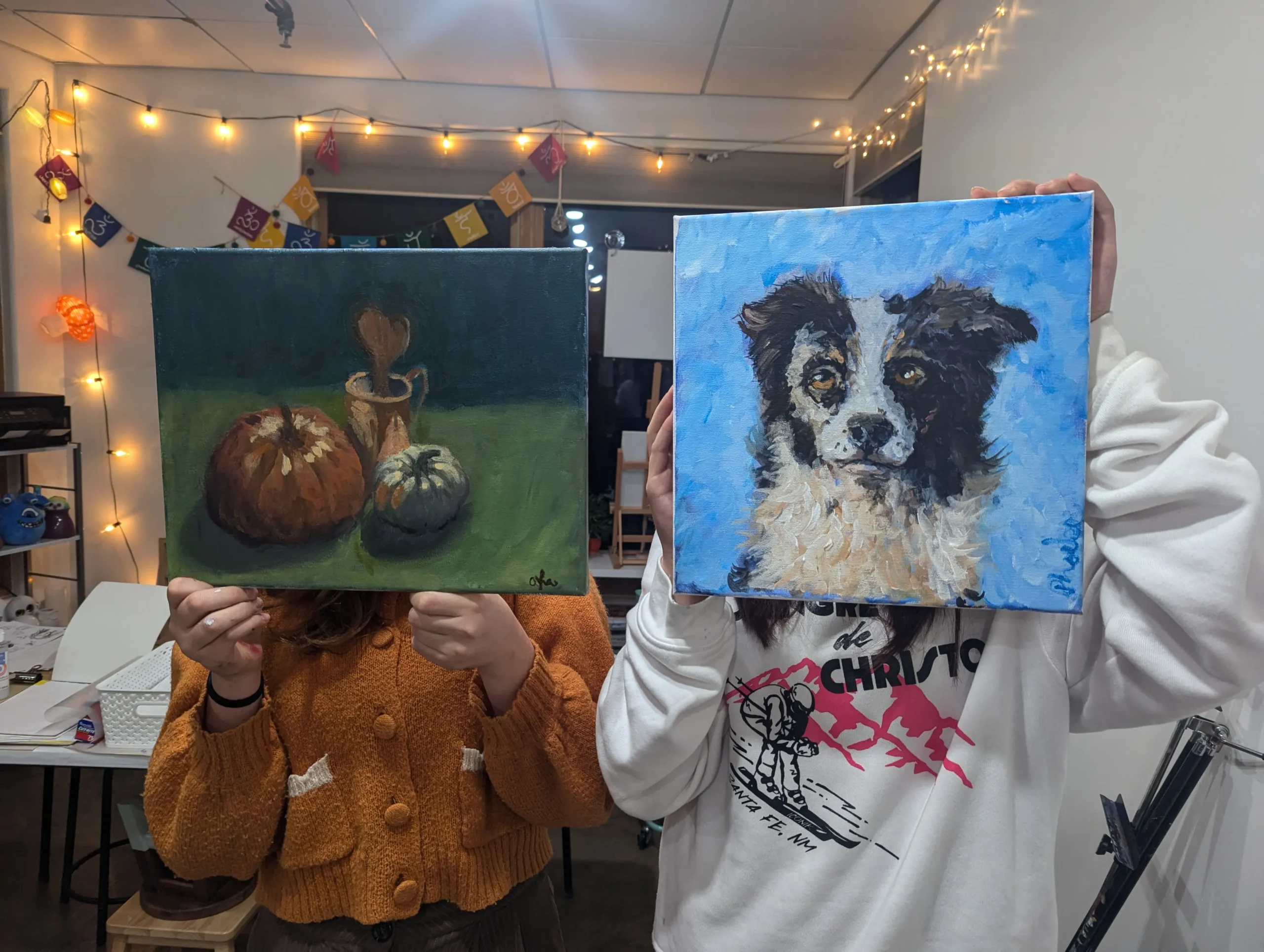 two students holding up their artwork