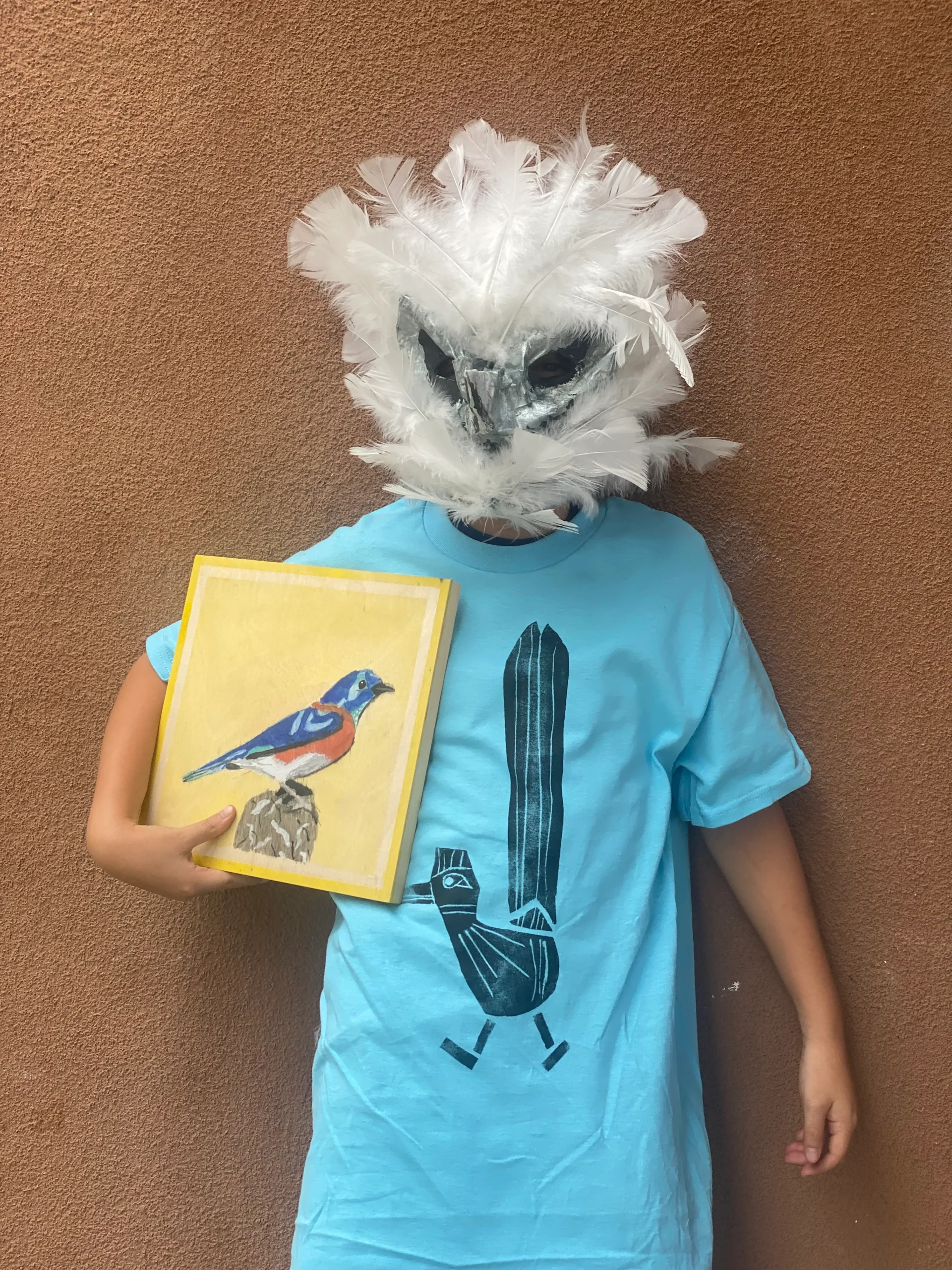 boy with bird mask showing bird painting