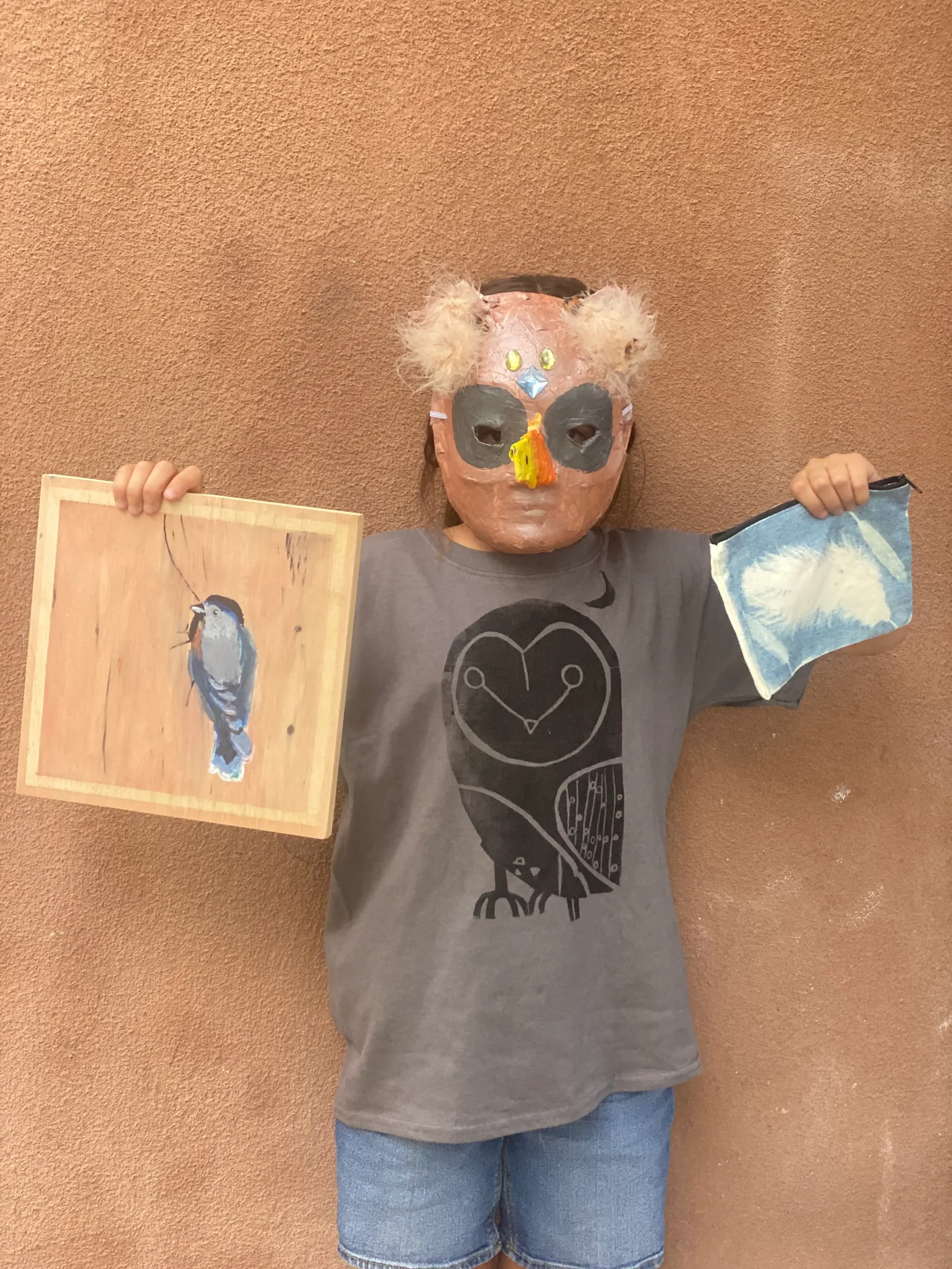 student with mask showing artwork of bird