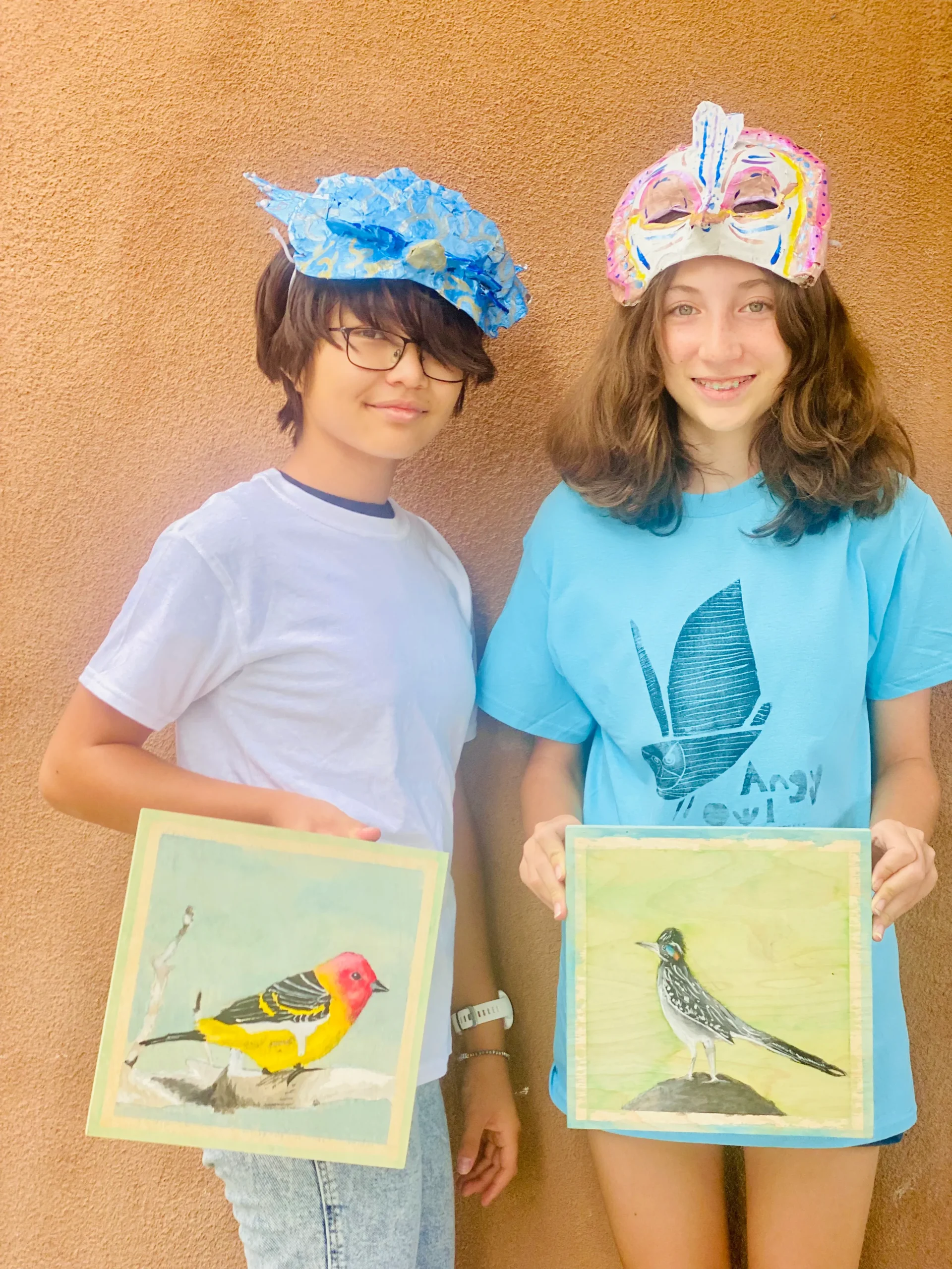 two students showing their bird artwork