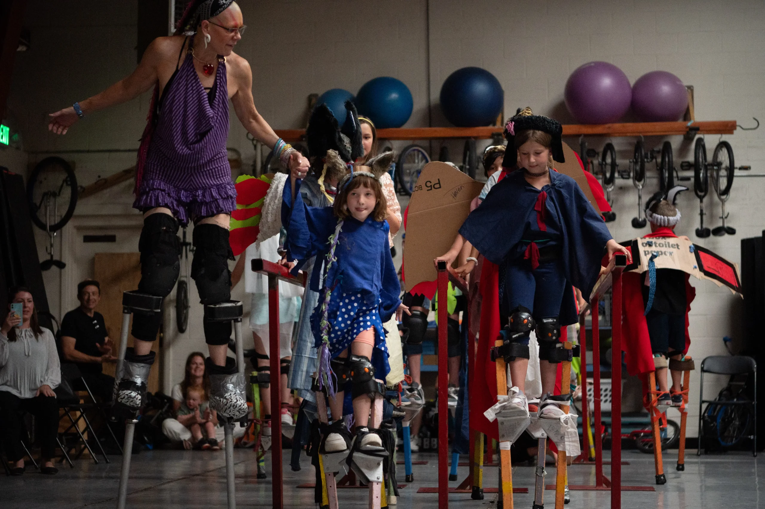 Youth demonstrating their stilt-walking skills with Coach Staz. Photo courtesy of Court Kessler.