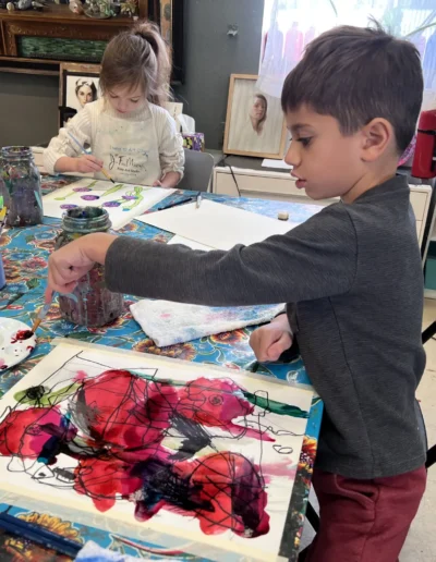 boy painting red flowers