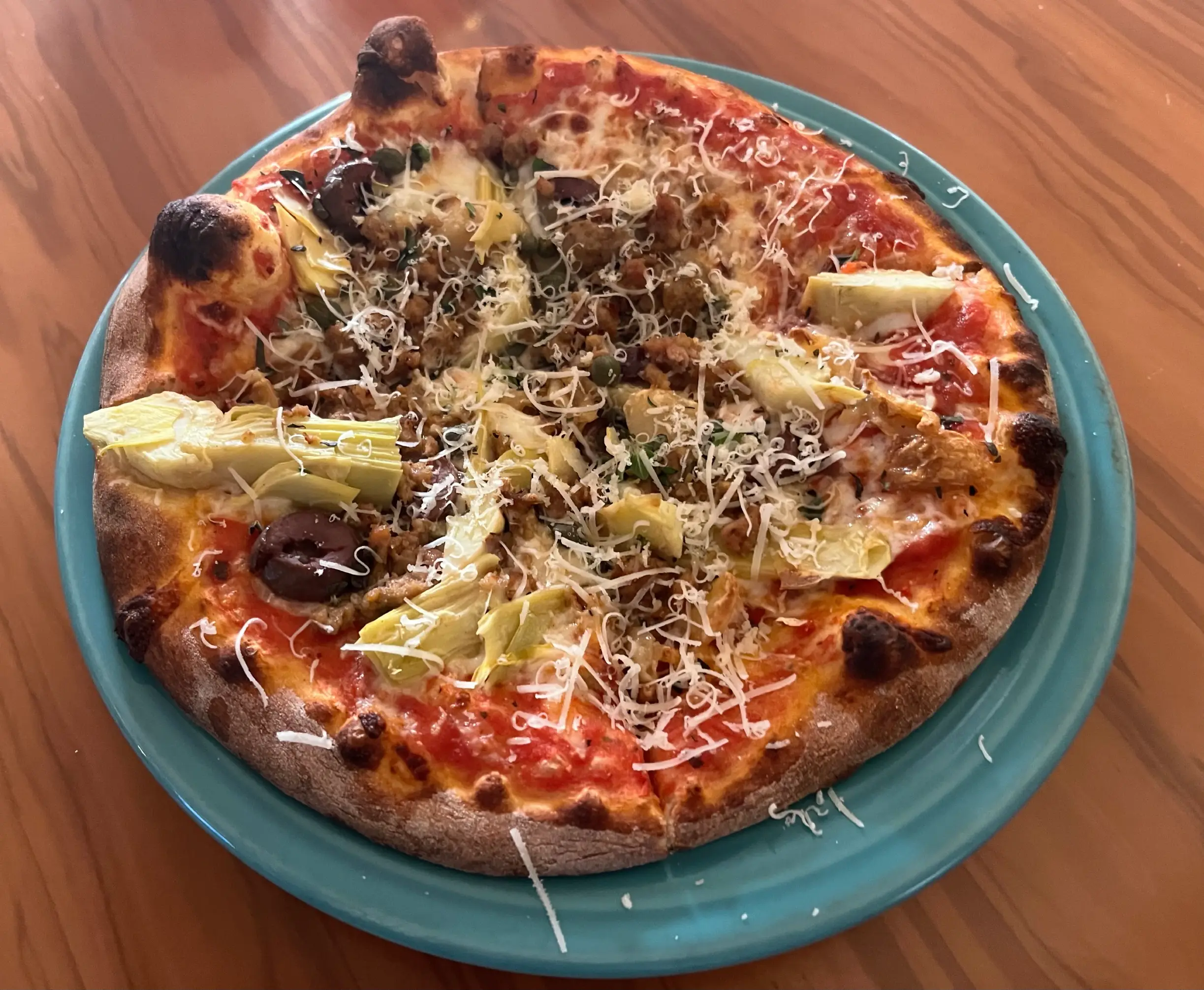 Il Vicino bambino pizza with artichoke hearts, capers, kalamata olilves, and sausage Il Vicino bambino pizza with artichoke hearts, capers, kalamata olilves, and sausage