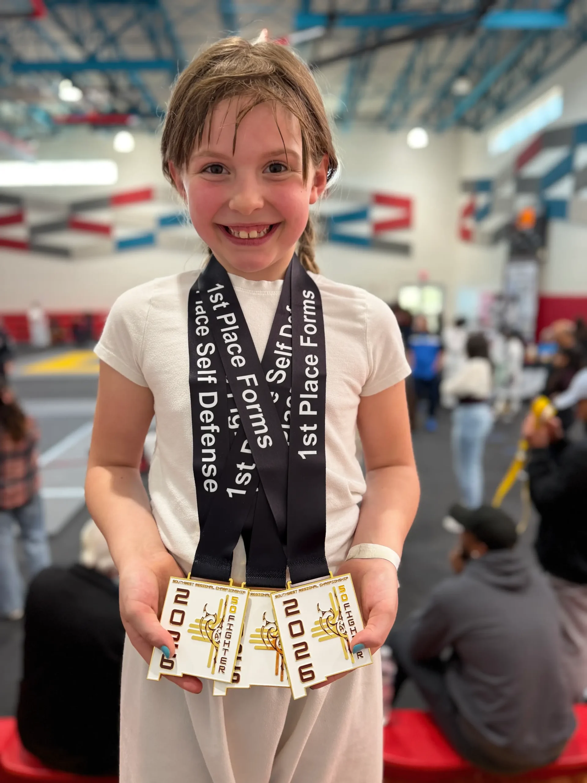 Clara presenting her three medals with a smile
