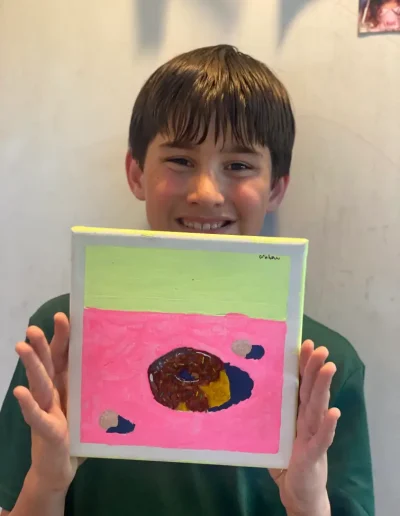 young student showing his painting