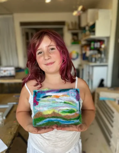girl student showing off landscape painting